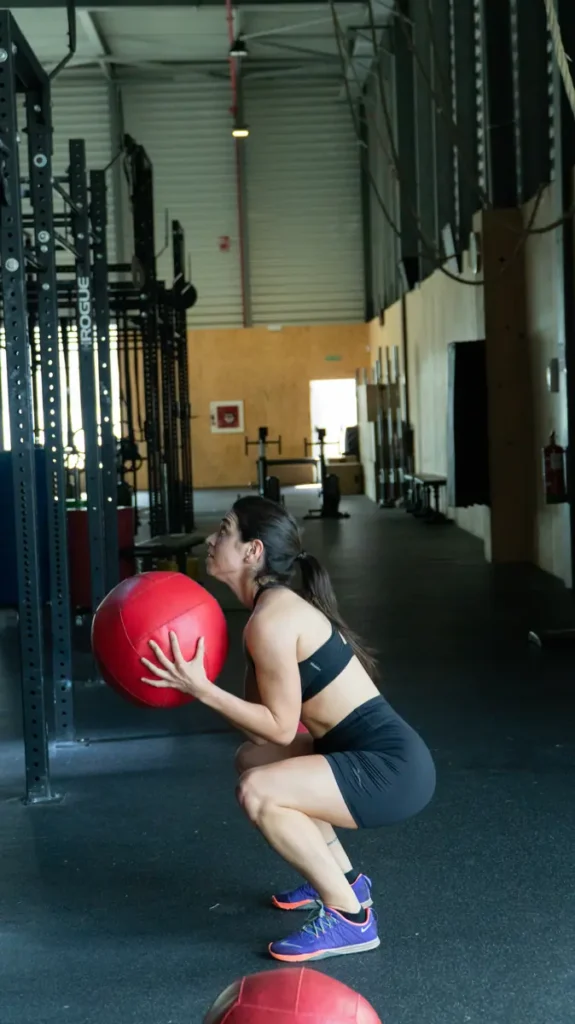 Mujer haciendo wall ball en una clase de entrenamiento funcional en Colen