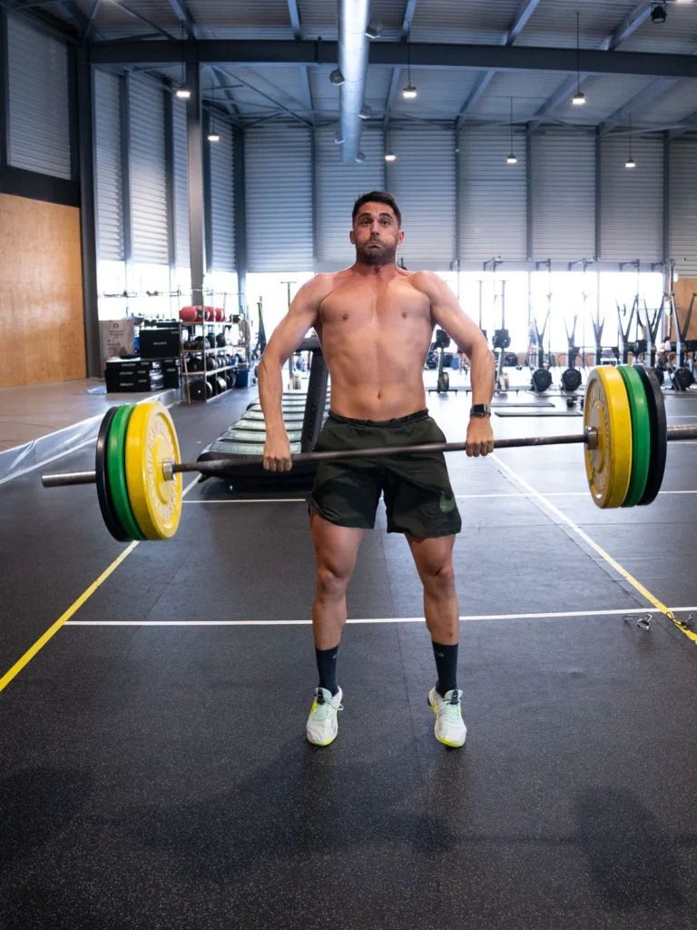 Atleta terminando un peso muerto con la barra cargada en la clase de fuerza de CrossFit Colen
