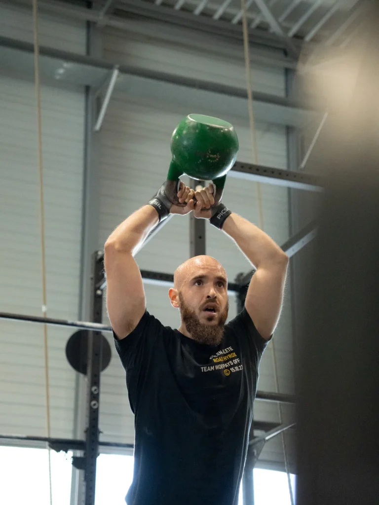 Trabajo accesorio con kettlebell por encima de la cabeza en la clase de entrenamiento de fuerza BUILD de CrossFit Colen